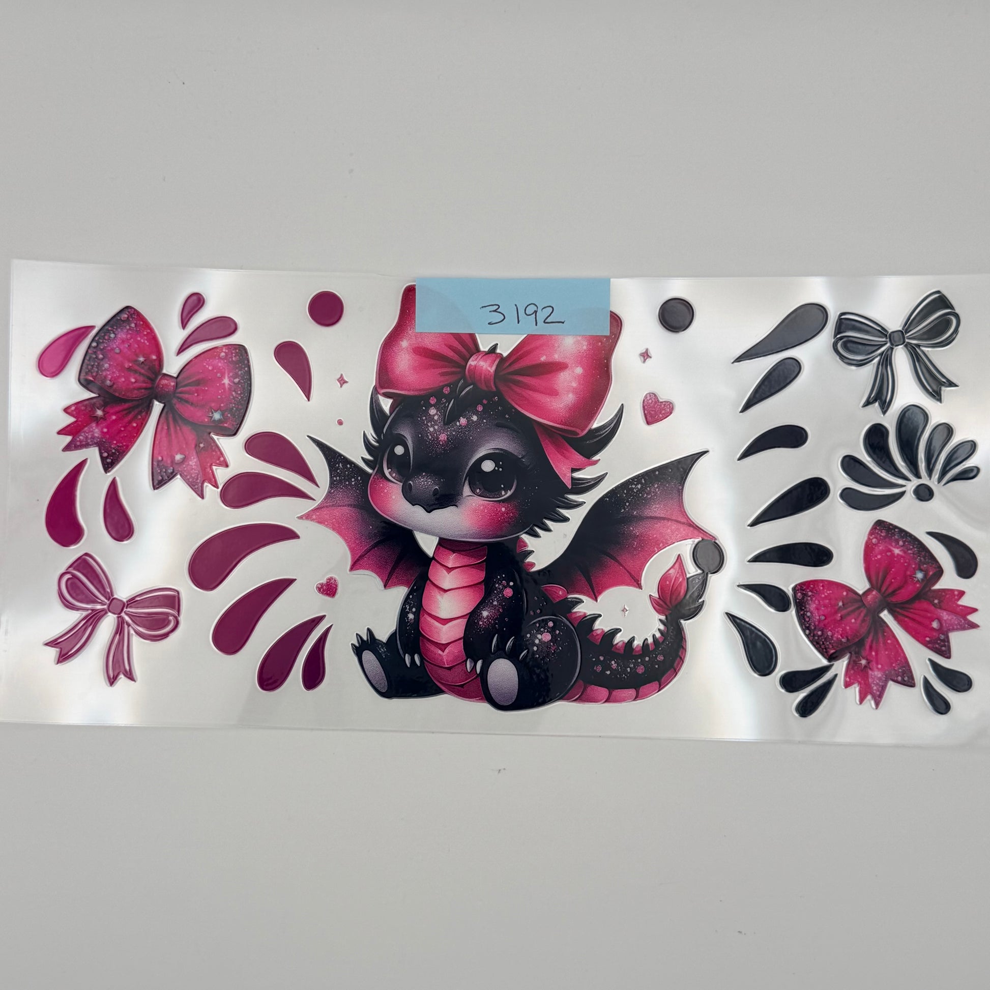 Pink and black dragon with bow