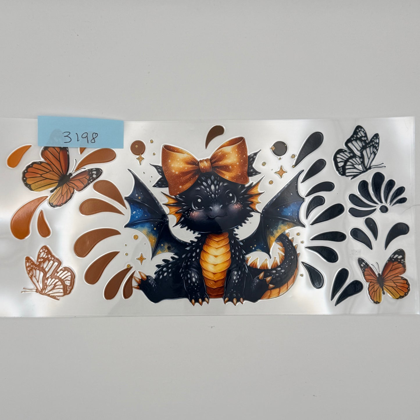 Black and gold dragon with bow and butterflies